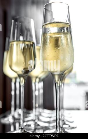 Cool champagne is poured into glass glasses. Condensation on the glass Stock Photo