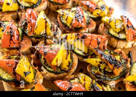 Grilled vegetables drizzled with sauce on slices of bread Stock Photo