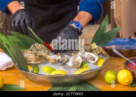The chef prepares oysters in the open air. Catering Stock Photo