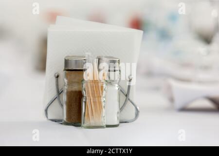 Toothpicks, salt and pepper shakers, and napkins on the table. Fragment of table setting Stock Photo