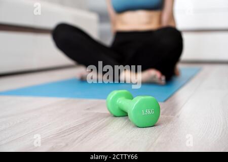 Close up of dumbbell and woman stretching in blurred background. Healthy lifestyle concept Stock Photo