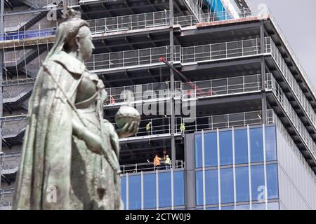 The statue of Queen Victoria situated in Victoria Square is dwarfed by the new 26 storey building under construction at 103 Colmore Row. Stock Photo