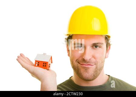 Construction worker with helmet holds house in hand Stock Photo