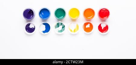 Six jars of paint on a white background Isolated Multicolored gouache Top view Top view Copy space Banner Horizontal Stock Photo