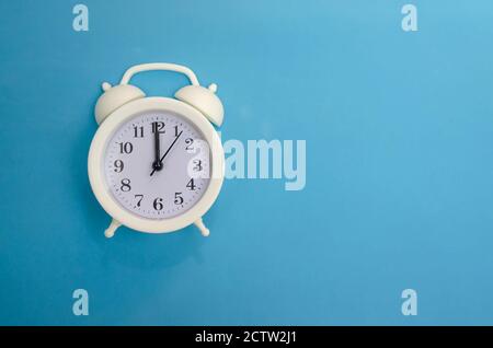 White alarm clock on blue background, copy space Stock Photo