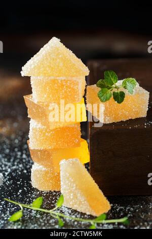 Fruit jelly candies. Homemade orange, pear or apricot candies in sugar on dark background. Fruit chewy candy. Jelly Bean. Assortment of colorful fruit Stock Photo