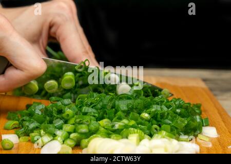 Woman Cuts Green Onion With Scissors Over A Cutting Board Stock Photo -  Download Image Now - iStock