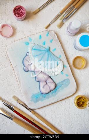 Painted gingerbread on a white background. Gingerbread in flat lay composition with food colors and brushes Stock Photo