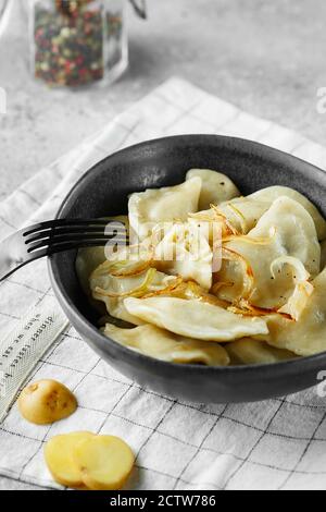 Dumplings, filled with mashed potatoes and onions. Russian, Ukrainian or Polish dish: varenyky, vareniki, pierogi, pyrohy. Food photography. Stock Photo