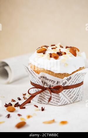 Easter composition. Easter cake decorated with almond petals and chocolate chips on white background Stock Photo