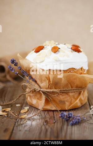 Easter composition. Easter cake decorated with almond petals and dry lavender on a rustic wooden background Stock Photo