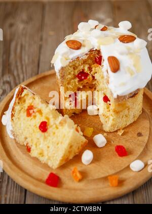 Easter composition. Easter cake decorated with almond petals on a rustic wooden background Stock Photo