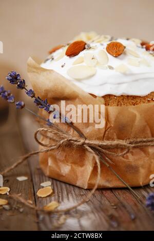 Easter composition. Easter cake decorated with almond petals and dry lavender on a rustic wooden background Stock Photo