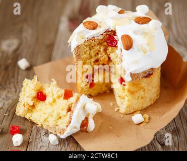 Easter composition. Easter cake decorated with almond petals and marshmallows on a rustic wooden background Stock Photo