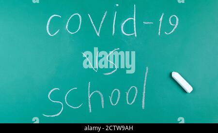 On the green chalkboard is written ovid 19 , School, top view, copy space Stock Photo