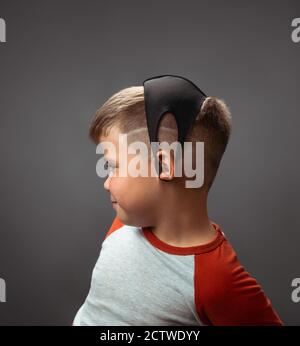 Boy with a medical mask on his head. Children in quarantine concept. Portrait of a boy in profile with a protective mask. High quality photo Stock Photo
