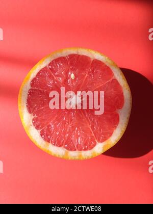 Slice, half a grapefruit on red Stock Photo
