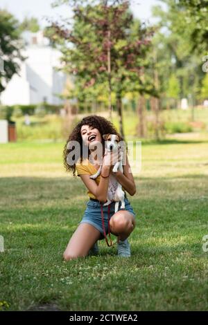 Selective focus of young woman holding jack russell terrier dog and laughing Stock Photo