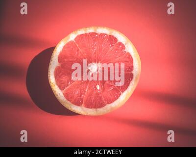 Slice, half a grapefruit on red Stock Photo