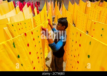 Bangladeshi workers collect fabric after dry them under the sun at a dyeing factory in Narayanganj, near Dhaka, Bangladesh, November 7, 2019. Stock Photo
