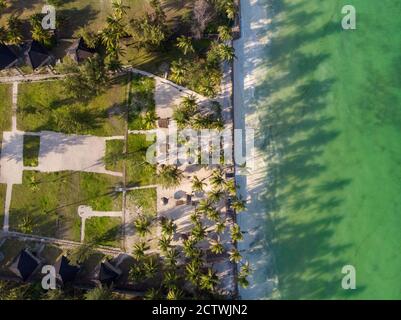 Aerial shot of a luxury hotel on a Beach first line with Palm Trees Drops their Shades on a High Tide Water of Indian Ocean at evening time in Paje Stock Photo