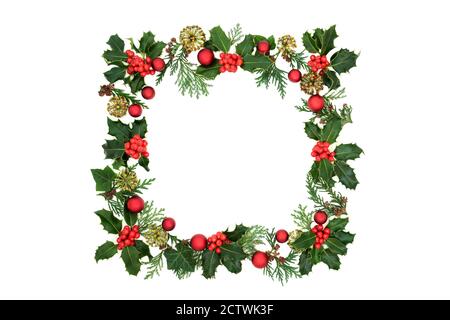 Christmas square wreath decoration with winter holly, red bauble decorations, cedar leaves & ivy florets on white background. Decorative background bo Stock Photo