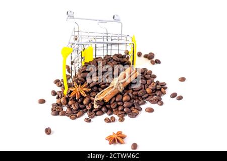 small shoping car with coffee. Coffee, cinnamon, anise stars scattered on a white background. Isolated Stock Photo