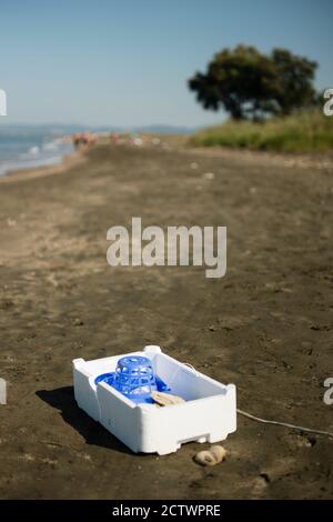 Plastic, white, styrofoam container left on sandy beach. Stock Photo