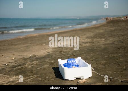 Plastic, white, styrofoam container left on sandy beach. Stock Photo