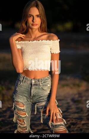 Girl in blur denim and red crop top | Sitting poses, Garden photography,  Girl poses