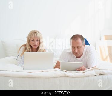 Mature married couple planning travel, choosing vacation, looking for tickets, booking hotel. Stock Photo