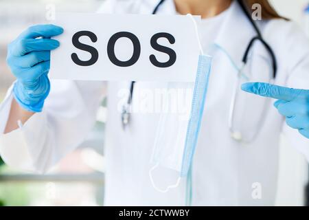 The doctor holds a form with the text sos Stock Photo