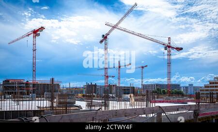 Panorama of Cranes on a Large Construction Site with Dramatic Sky Stock Photo