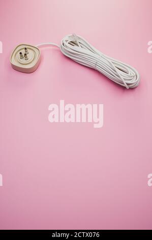 Vertical shot of an electrical extension cord isolated on pink background Stock Photo