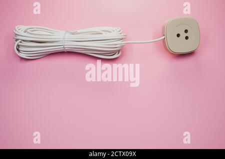 Closeup of an electrical extension cord isolated on pink background Stock Photo