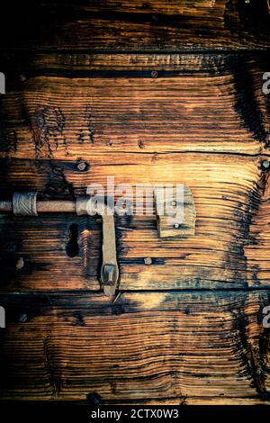 Larch wood door with wrought iron bolt Stock Photo