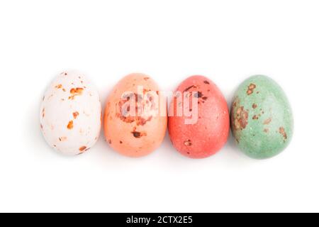 Four chocolate eggs candies isolated on white background. close up, top view, flat lay. Stock Photo