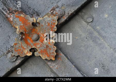 Fragment of ancient peeling and decayed monastery gates with rusty skillfully forged decorative overlay.  Stock Photo