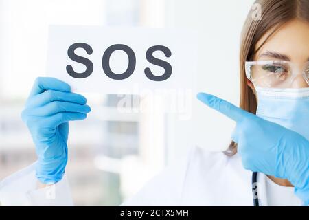 The doctor holds a form with the text sos Stock Photo