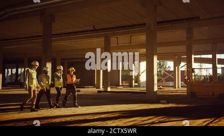 Diverse Team of Specialists Walk Through Garage Level of Industrial Commercial Building Construction Site. Real Estate Project with Civil Engineer Stock Photo
