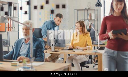 In the Busy Office: Group of Professional Businesspeople Working on Desktop Computers, Talking With Colleagues. Business Management Optimizing Stock Photo