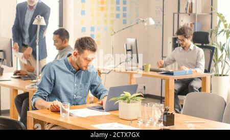 Modern Startup Chief Analyst Works on a Computer under Firm Strategy, Analyzes Data and Information. Modern Office of a new Company with Diverse Stock Photo