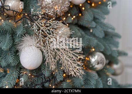 New Year's Tree close-up. Christmas tree branches are decorated with balloons and garlands. Silver branches decorate the tree. High quality photo Stock Photo