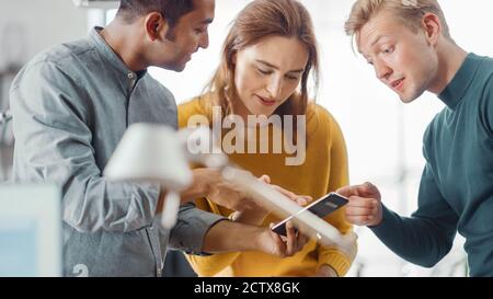 Three Start-up Entrepreneurs Have Meeting and Discussion about Project, They Discuss Project Design, Share Touch Screen Digital Tablet Screens. Modern Stock Photo