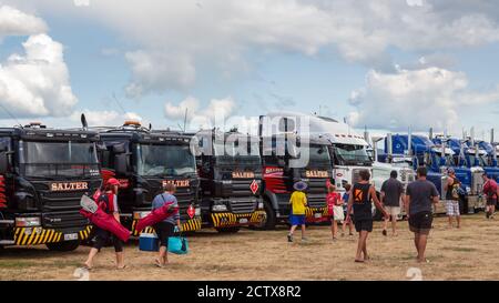 People walking past a row of big rig trucks of various makes and models at a truck show. Mount Maunganui, New Zealand, January 18 2020 Stock Photo