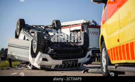 Shot of Rollovered Ca after Horrific Traffic Accident. Rescue Team of Firefighters and Paramedics Arrived on a Terrible Car Crash Traffic Accident Stock Photo
