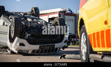 Shot of Rollovered Ca after Horrific Traffic Accident. Rescue Team of Firefighters and Paramedics Arrived on a Terrible Car Crash Traffic Accident Stock Photo
