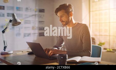Professional Creative Man Sitting at His Desk in Home Office Studio Working on a Laptop, Concentrated Man Using Notebook Computer. Stock Photo
