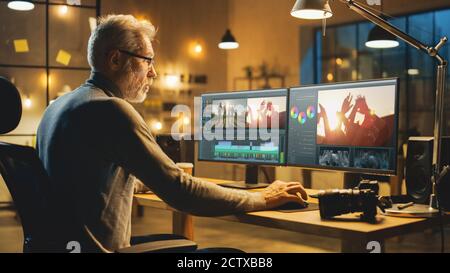 Evening in Creative Office: Professional Middle Aged Videographer Works on Desktop Computer, Doing Footage Montage, Using Video Editing Software Stock Photo