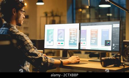 Late Evening Creative Office: Professional Programmer Works on a Desktop Computer, Creating Phone App Design, Using Editing Software. Modern Stylish Stock Photo